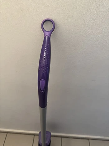 Front view of the purple mop handle with a purple spray button for releasing solution onto the floor