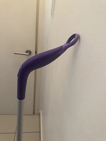 Close-up of the purple curved mop handle with small indents for grip