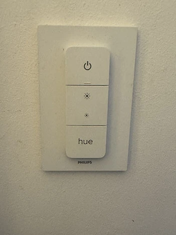White magnetic Philips Hue remote placed in its white base
